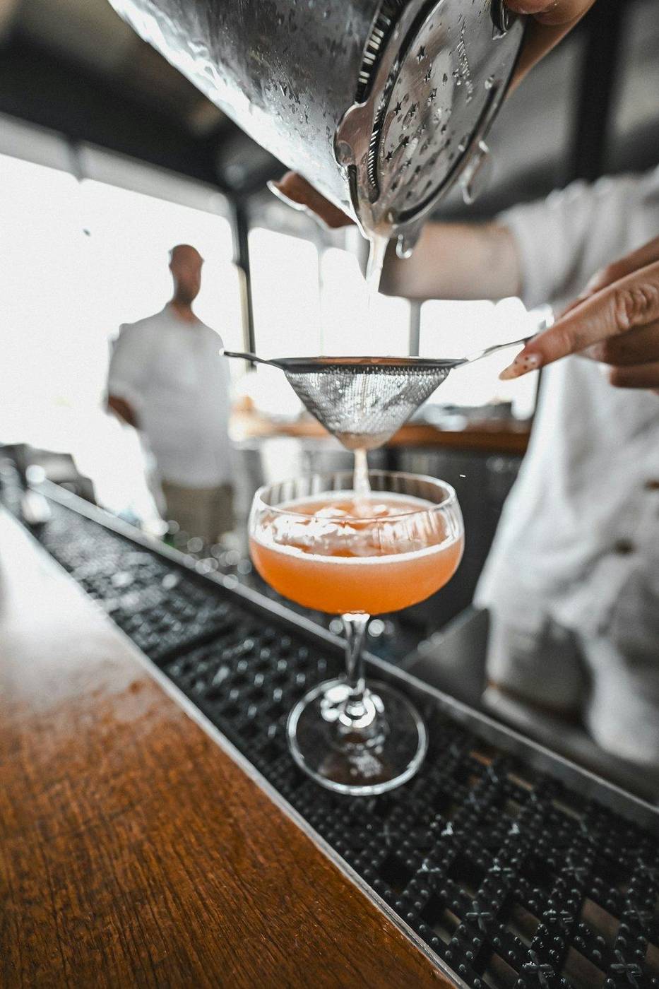 A cocktail being strained